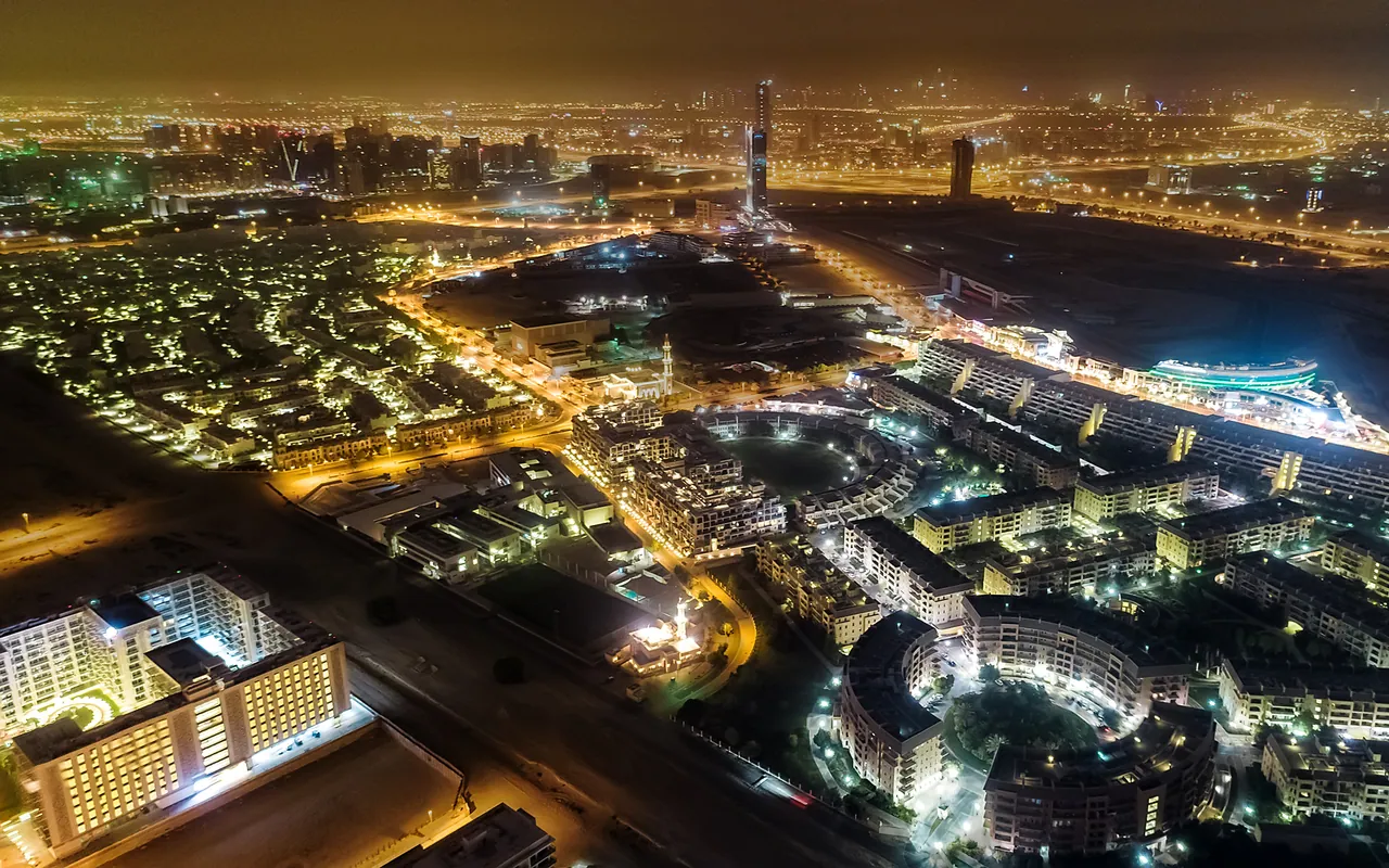 Aerial night view of residential buildings and streets in Dubai Motor City