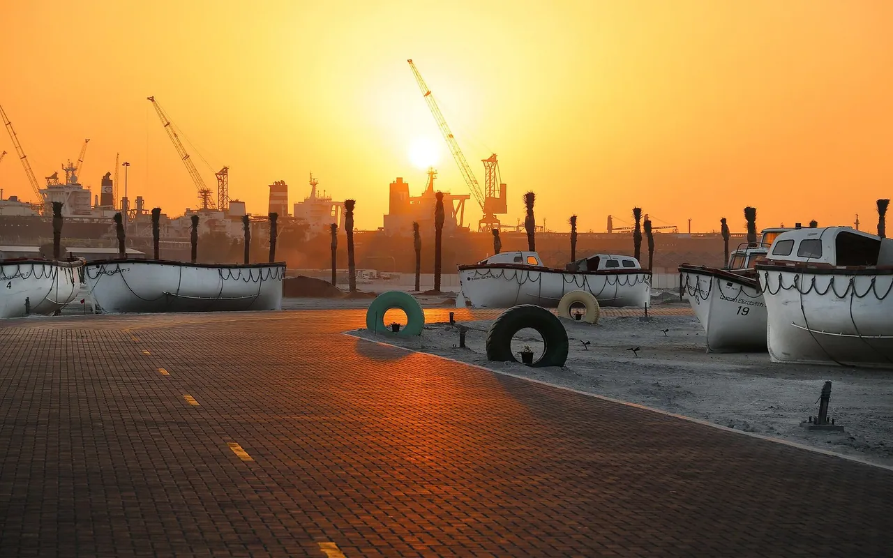 Sunset over Port Rashid with moored QE2 lifeboats in 2018