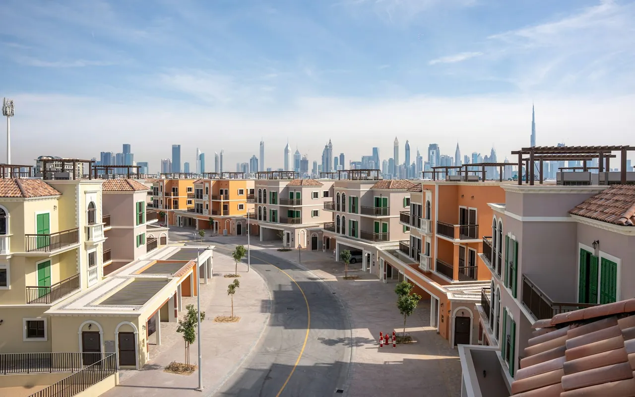 Residential townhouses on a quiet street in Dubai, with the distant city skyline — representative Dubai photograph, not a view of Damac Hills 2