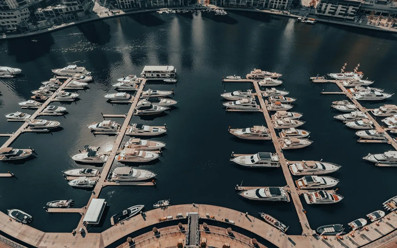 An aerial view of yacht berths and calm water in Dubai Marina