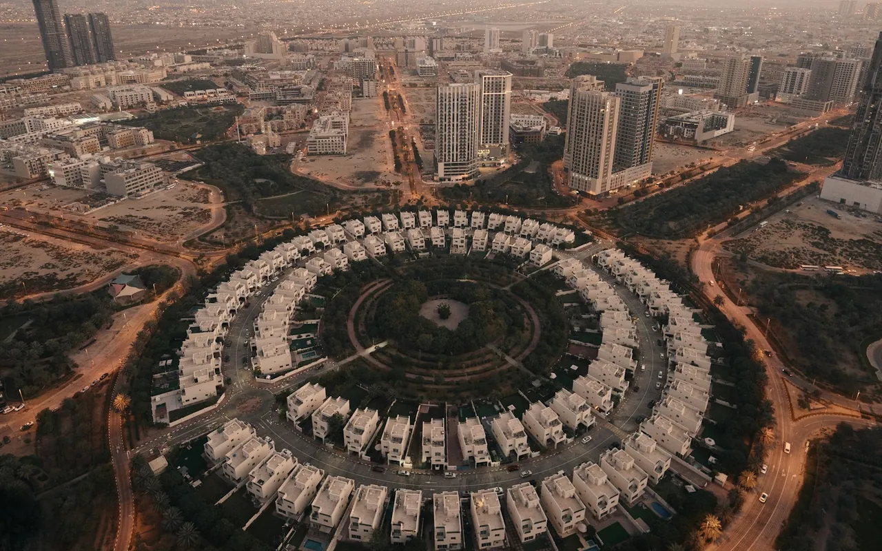 Aerial view of villas arranged around a circular park in Jumeirah Village Circle, Dubai