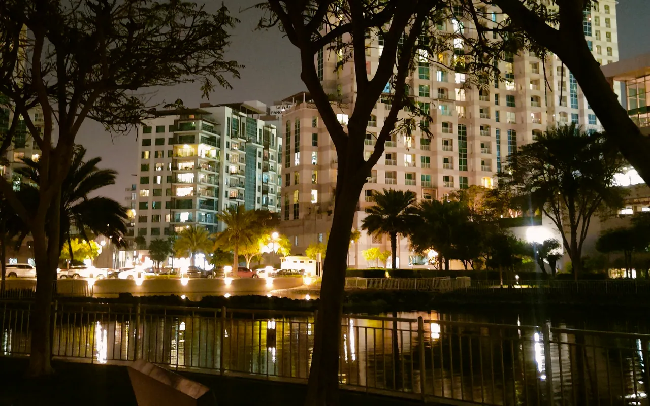 Illuminated residential towers beside the lake in The Views, Dubai