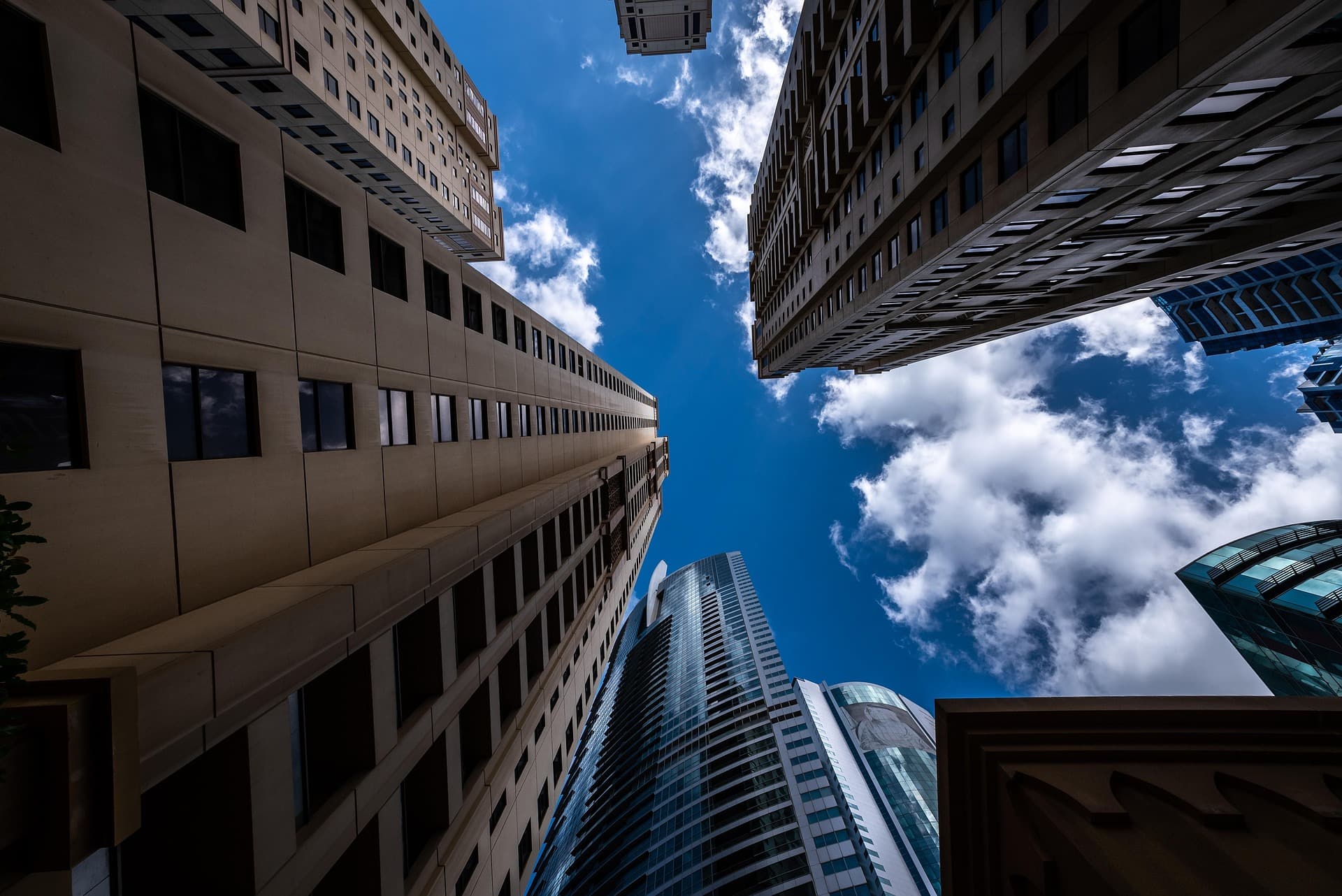 Looking up between high-rise residential towers to a blue sky
